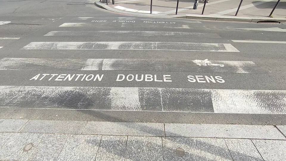 Marquage au sol Attention double sens sur un passage piéton